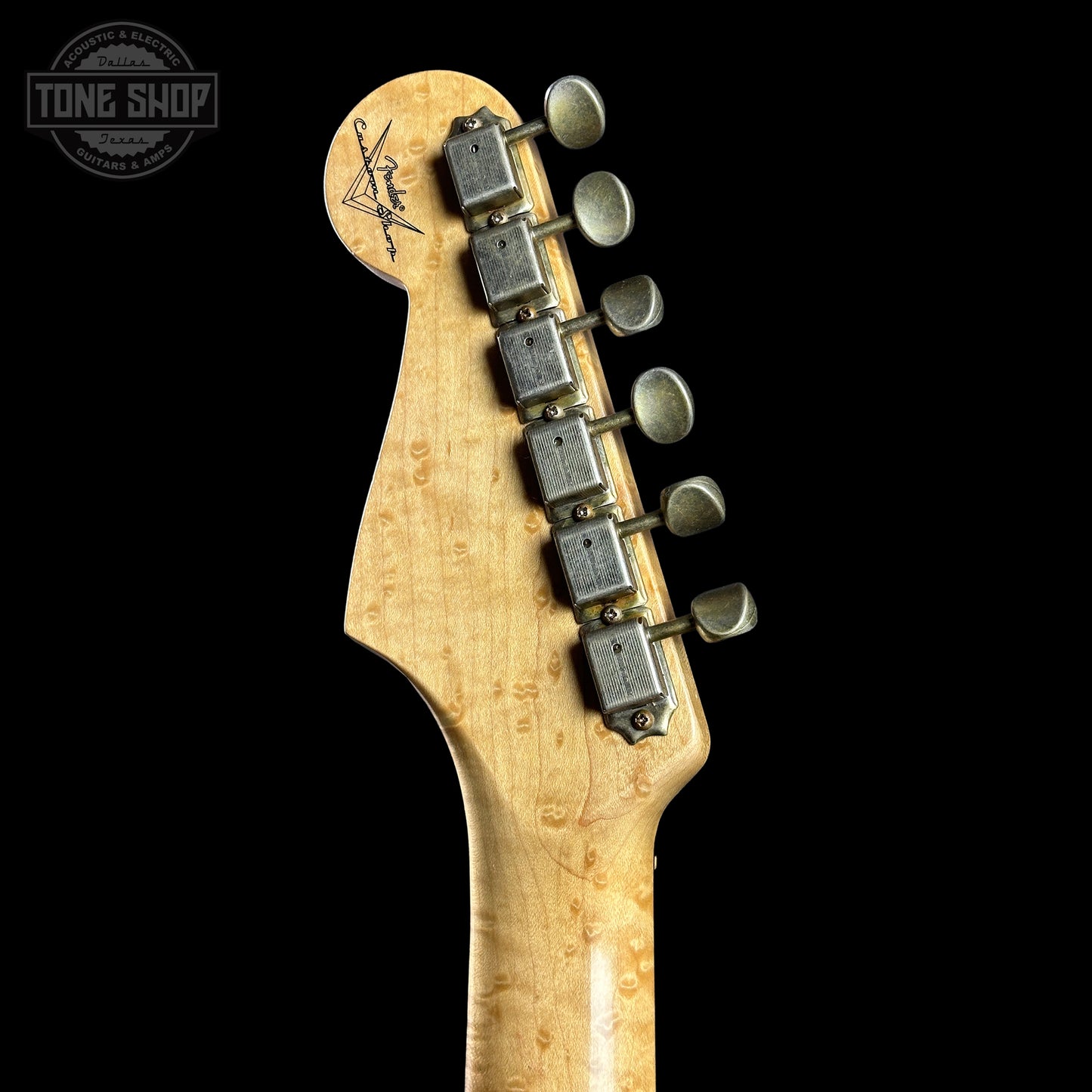 Guitar headstock with tuning pegs on a black background, featuring the Tone Shop logo.