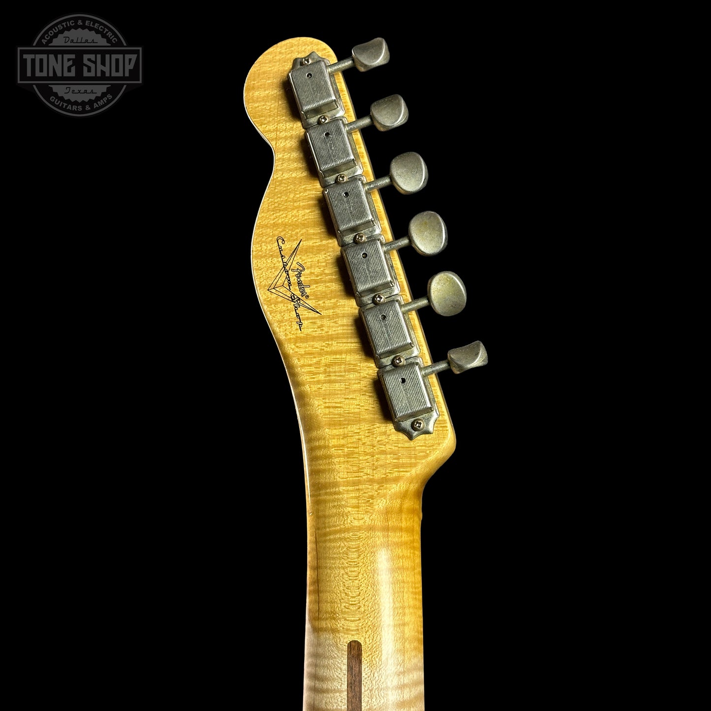 Guitar headstock with tuning pegs on a black background, featuring the Tone Shop logo.