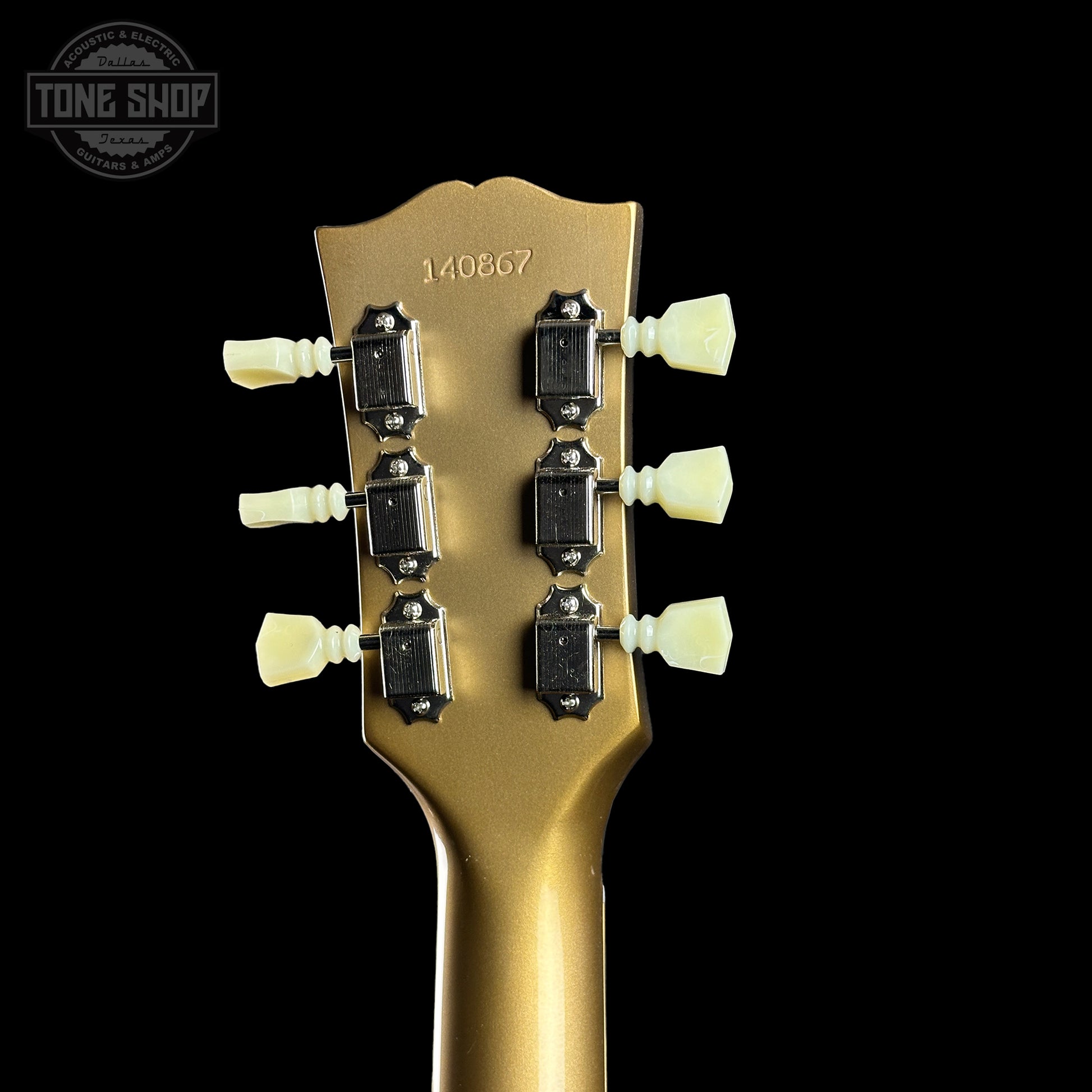 Gold guitar headstock with tuning pegs on a black background, featuring 'Tone Shop' logo.