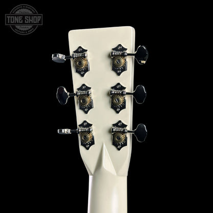 Close-up of a guitar headstock with tuning pegs on a black background, featuring the Tone Shop logo.