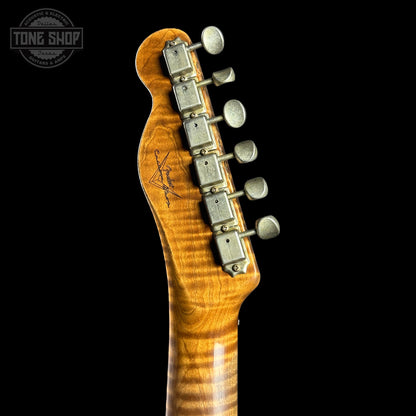 Close-up of a guitar neck with headstock and tuning pegs on a black background, featuring the Tone Shop logo.