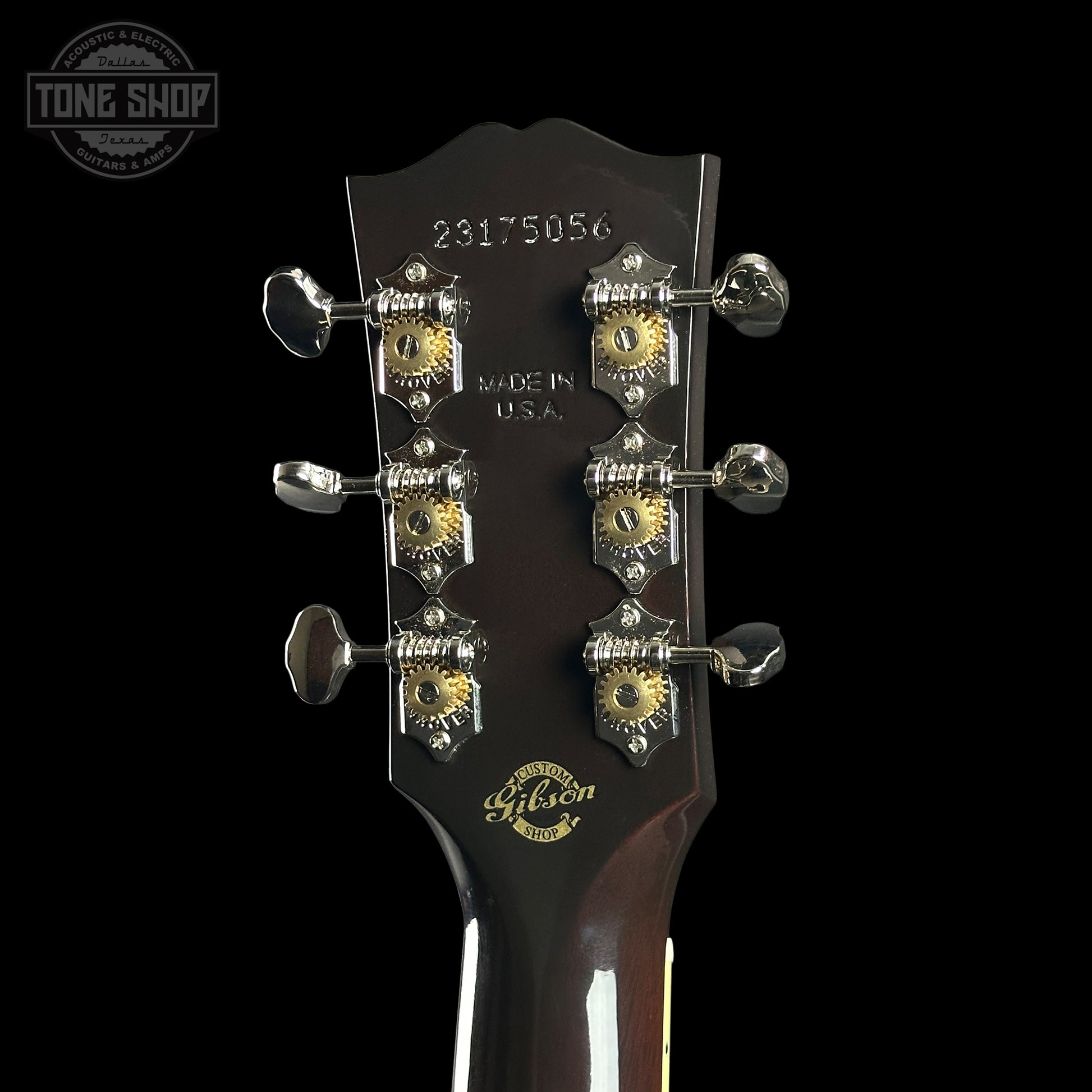 Gibson guitar headstock with tuning pegs on a black background
