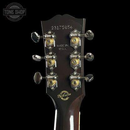 Gibson guitar headstock with tuning pegs on a black background