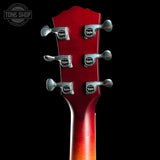 Close-up of a red guitar neck with tuning pegs on a black background, featuring the Taylor logo.