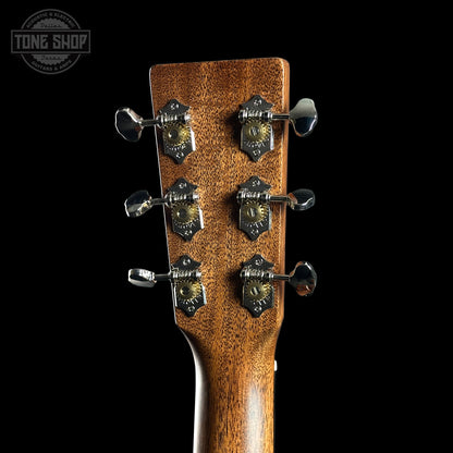 Close-up of a guitar headstock with tuning pegs on a black background, featuring the Tone Shop logo.