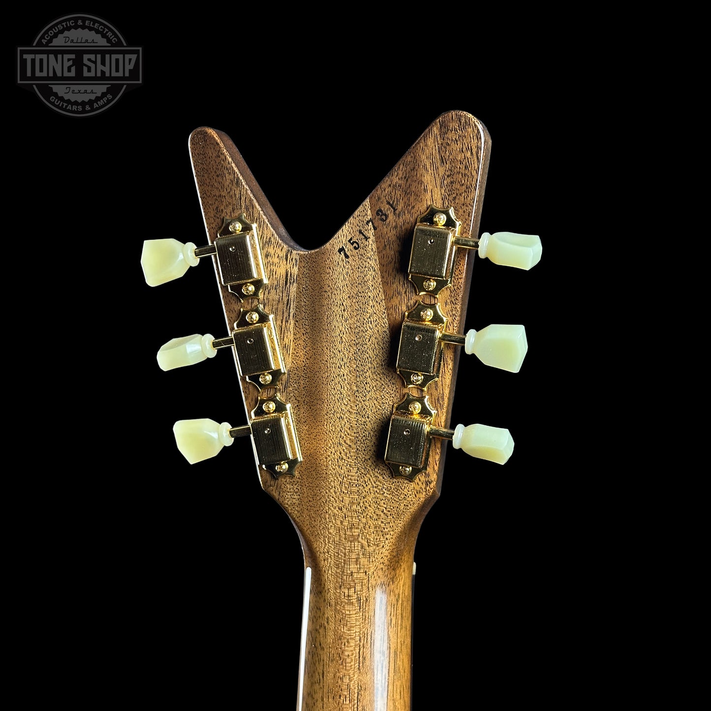 Close-up of a guitar headstock with tuning pegs on a black background, featuring the Tone Shop logo.