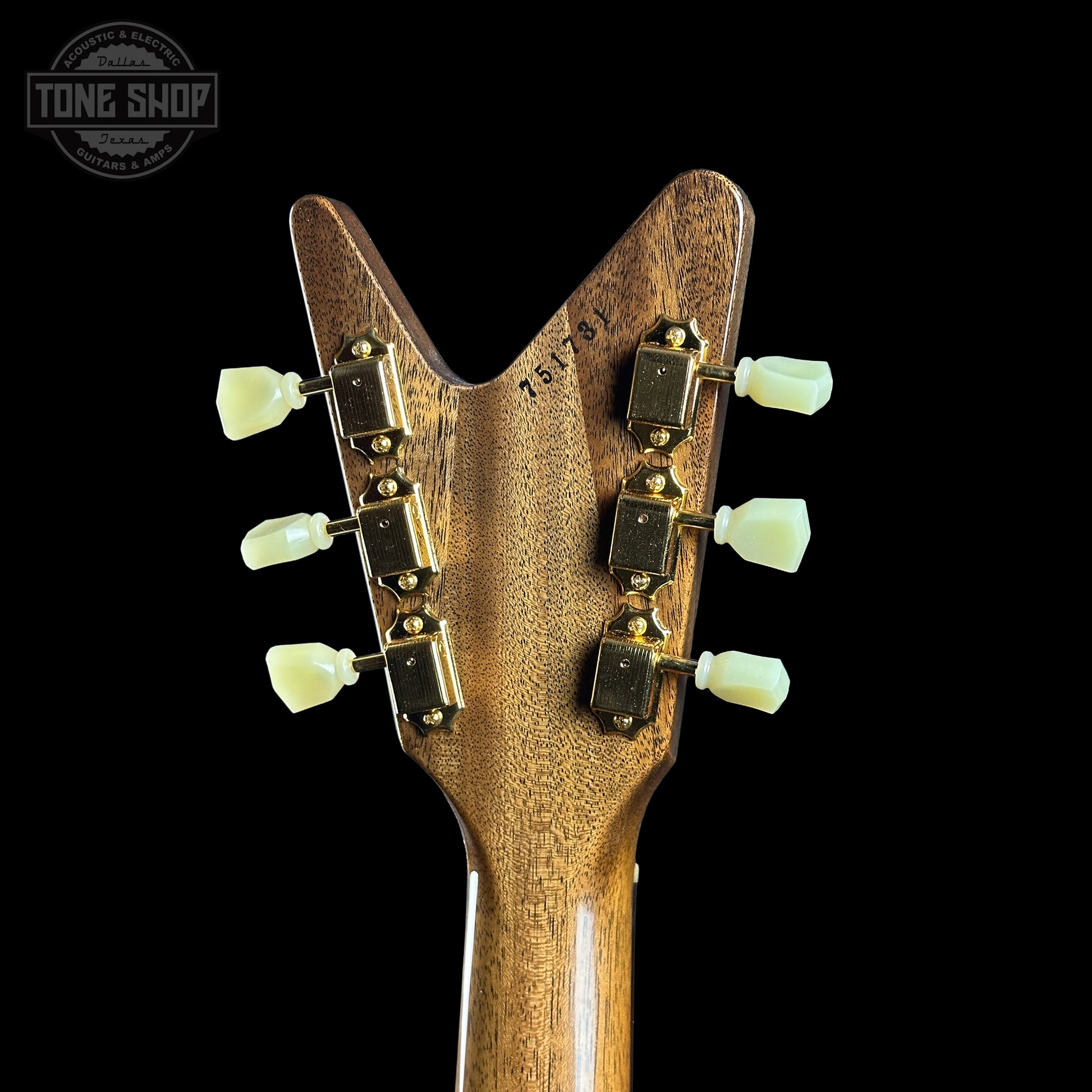 Close-up of a guitar headstock with tuning pegs on a black background, featuring the Tone Shop logo.