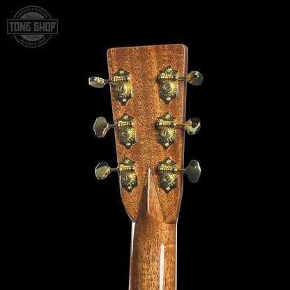 Close-up of a guitar headstock with tuning pegs on a black background, featuring the Tone Shop logo.