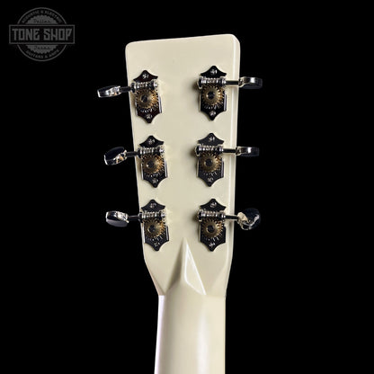 Close-up of a guitar headstock with tuning pegs on a black background, featuring 'Tone Shop' branding.