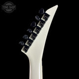 Close-up of a guitar neck with a white pickguard and black tuning pegs on a black background.