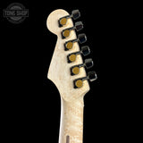 Close-up of a guitar headstock with tuning pegs on a black background, featuring the Tone Shop logo.