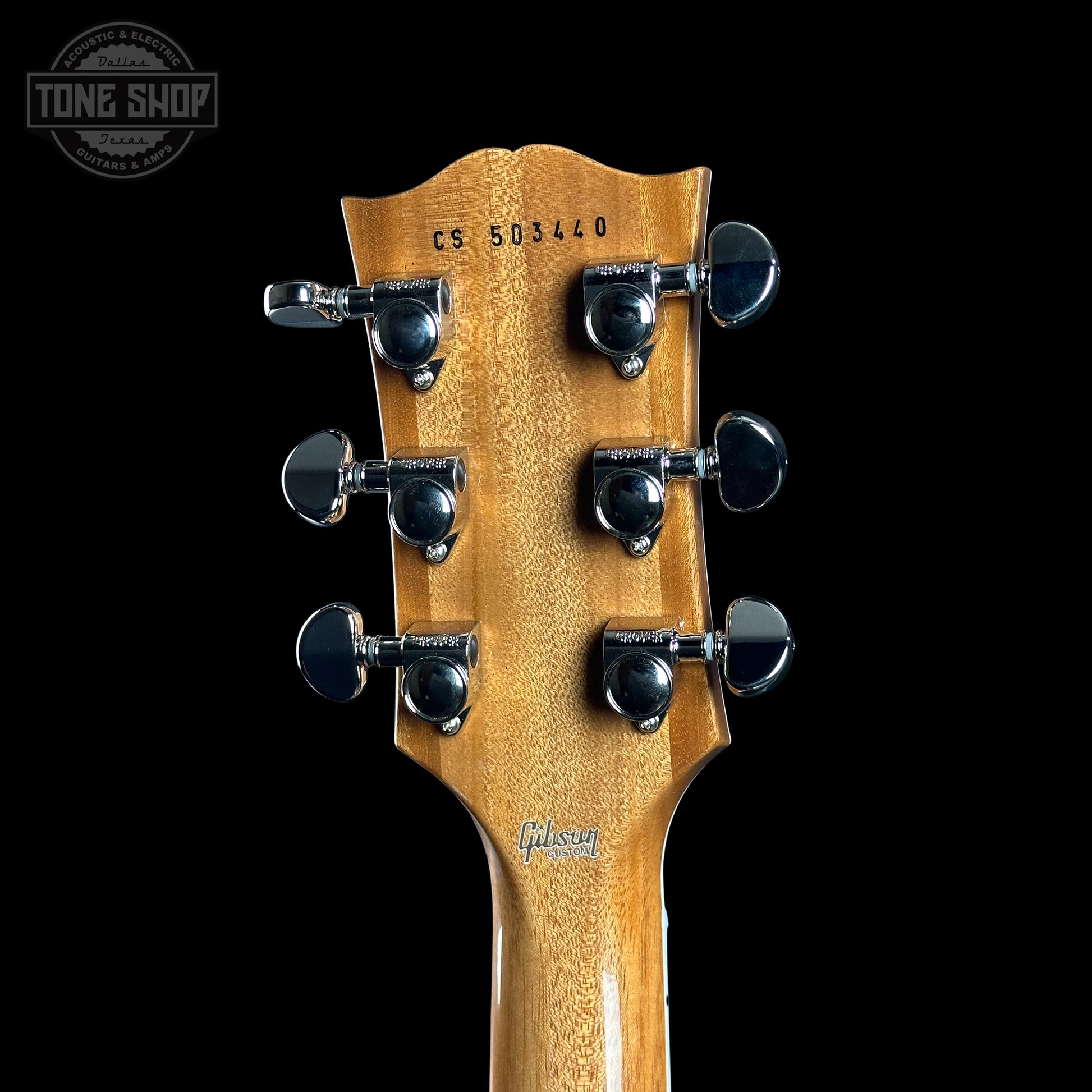 Gibson guitar headstock with tuning pegs on a black background