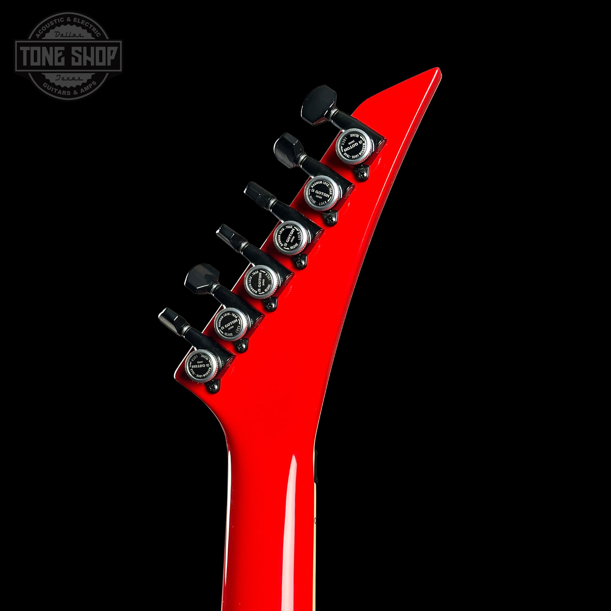 Red electric guitar neck with tuning pegs on a black background, featuring 'Tone Shop' logo.