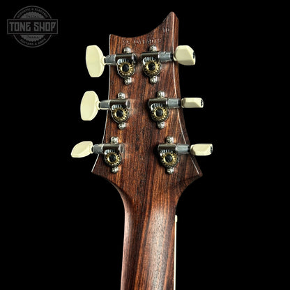 Close-up of a guitar headstock with tuning pegs on a black background, featuring the Tone Shop logo.