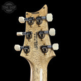 Close-up of a guitar headstock with tuning pegs on a black background, featuring the 'Tone Shop' logo.