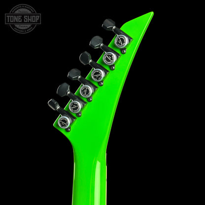 Close-up of a green guitar neck with tuning pegs on a black background, featuring 'Tone Shop' logo.