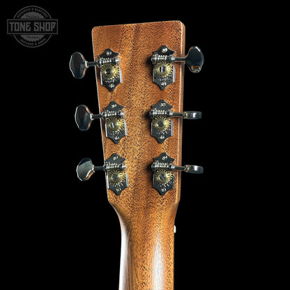 Close-up of a guitar headstock with tuning pegs on a black background, featuring the Tone Shop logo.