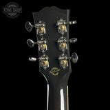 Gibson guitar headstock with tuning pegs on a black background