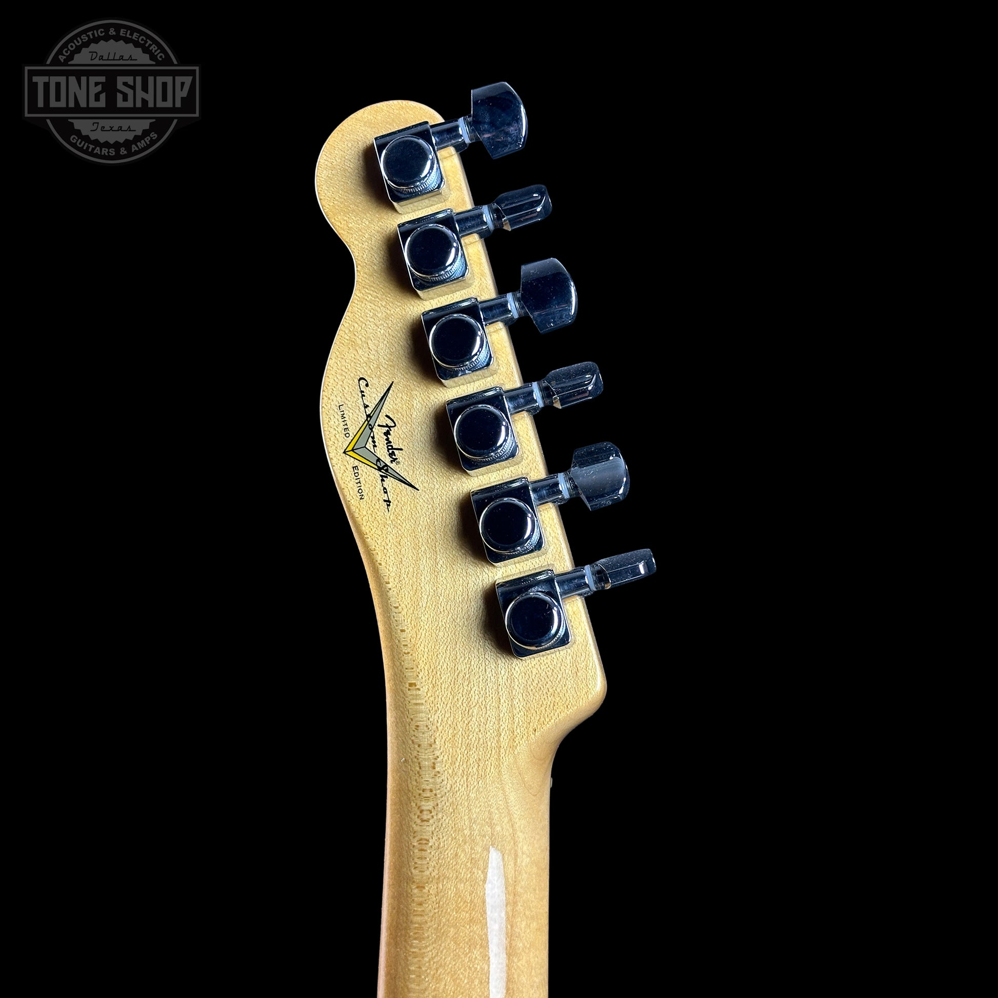 Guitar headstock with tuning pegs on a black background, featuring the Tone Shop logo.