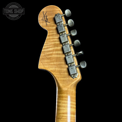 Close-up of a guitar headstock with tuning pegs on a black background, featuring the Tone Shop logo.