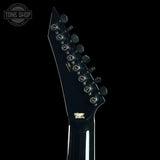 Close-up of a guitar neck with tuning pegs on a black background, featuring the Tone Shop logo.