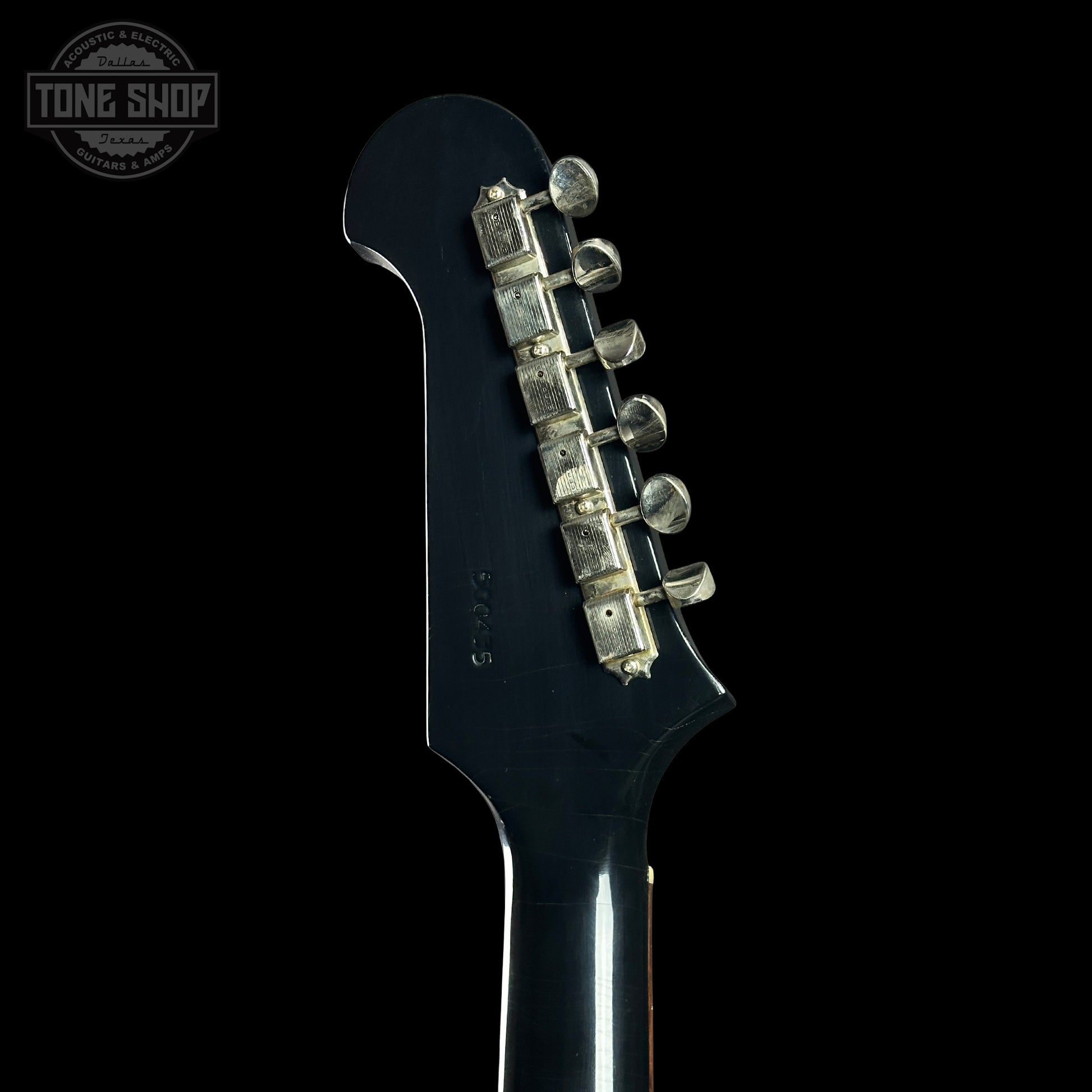 Close-up of a guitar headstock with tuning pegs on a black background, featuring 'Tone Shop' branding.