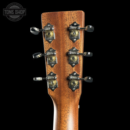 Close-up of a guitar headstock with tuning pegs on a black background, featuring the Tone Shop logo.