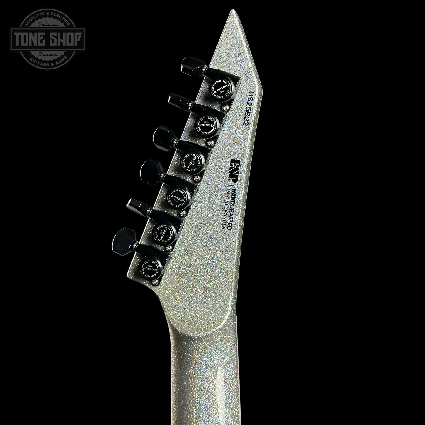 Close-up of a guitar's tuning pegs with a black background