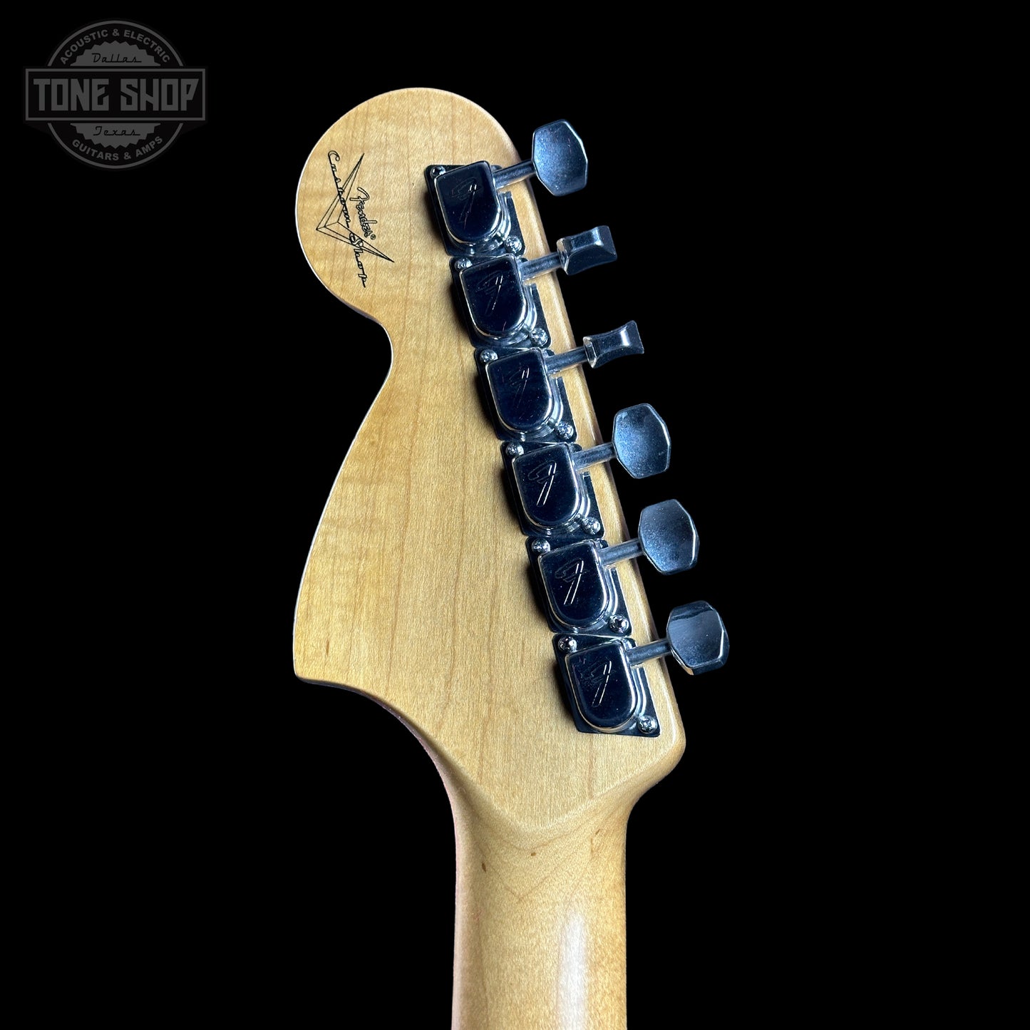 Guitar headstock with tuning pegs on a black background, featuring the Tone Shop logo.