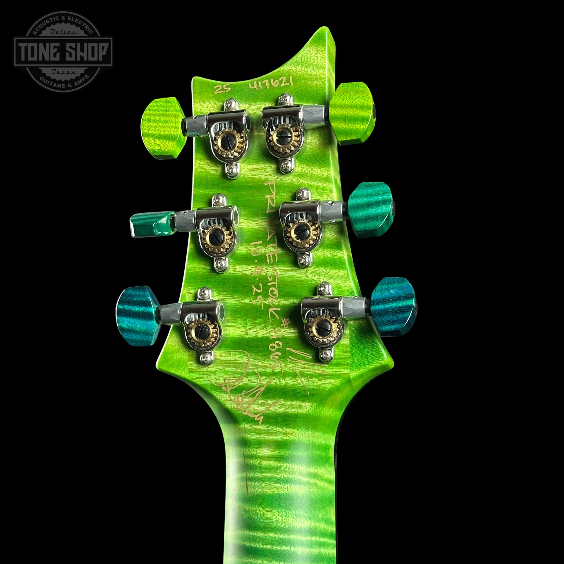 Close-up of a green guitar headstock with tuning pegs on a black background, featuring 'Tone Shop' branding.