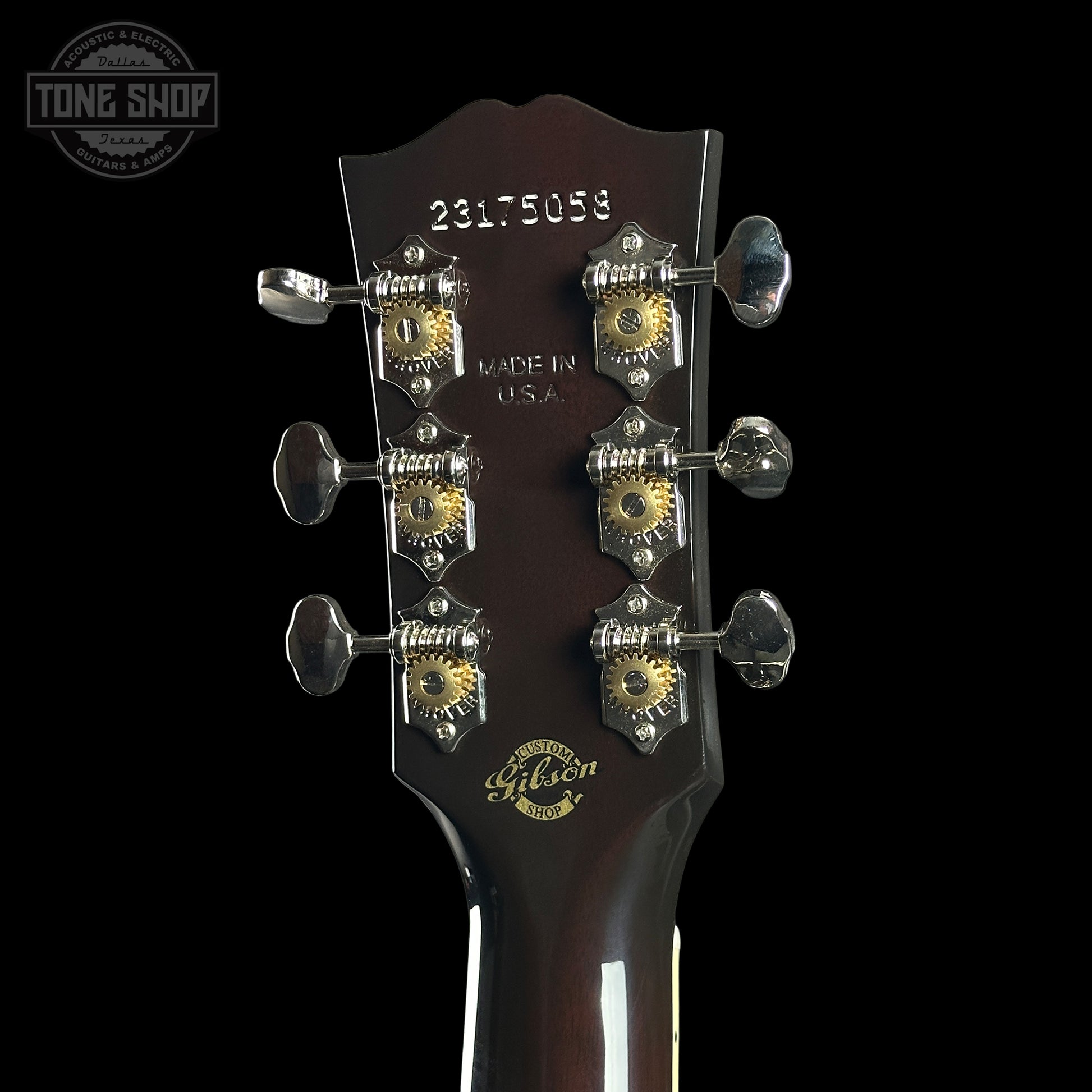 Gibson guitar headstock with tuning pegs on a black background
