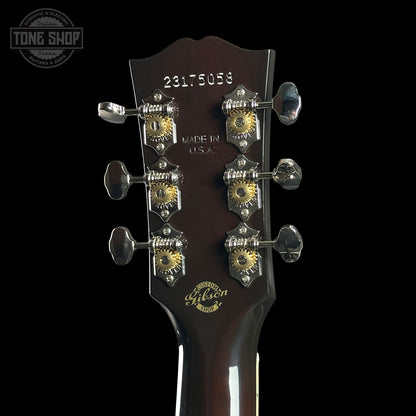 Gibson guitar headstock with tuning pegs on a black background