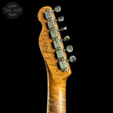Close-up of a guitar headstock with tuning pegs on a black background, featuring the Tone Shop logo.