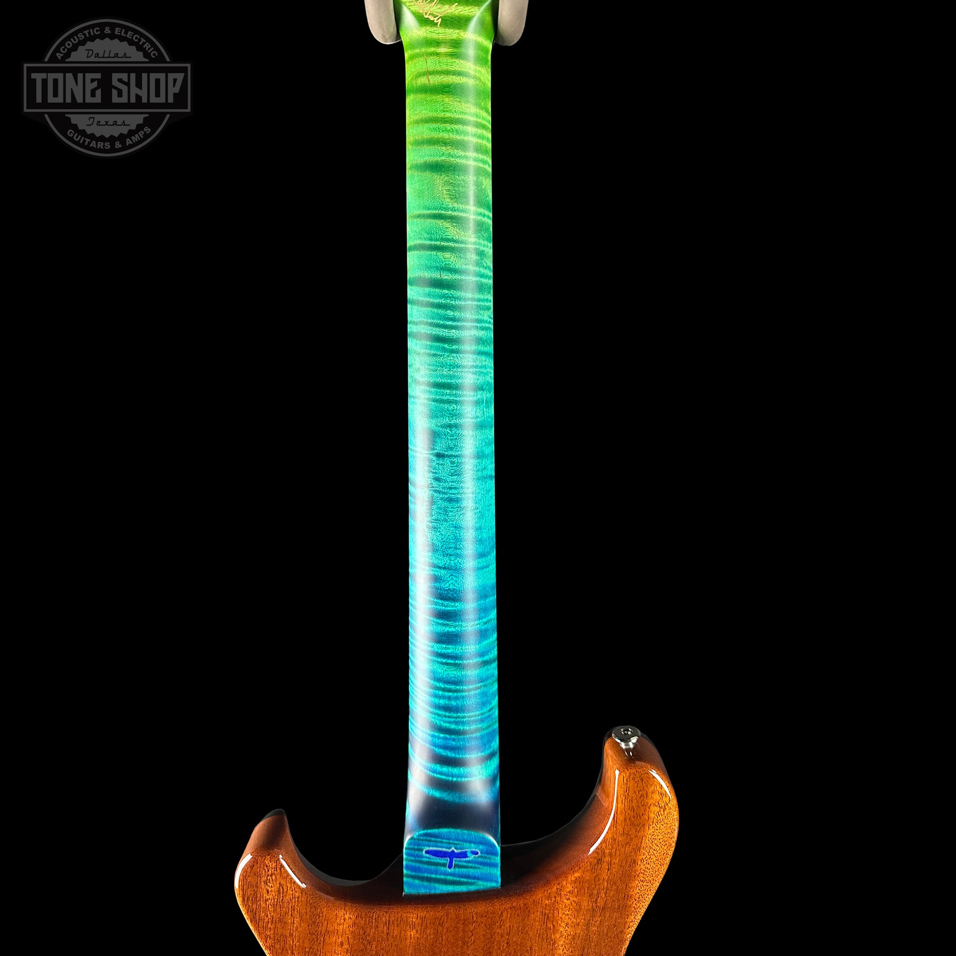 Guitar neck with a colorful swirl design on a black background, featuring the Tone Shop logo.