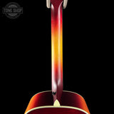 Close-up of a guitar's neck and headstock with a gradient color pattern on a black background, featuring the Tone Shop logo.