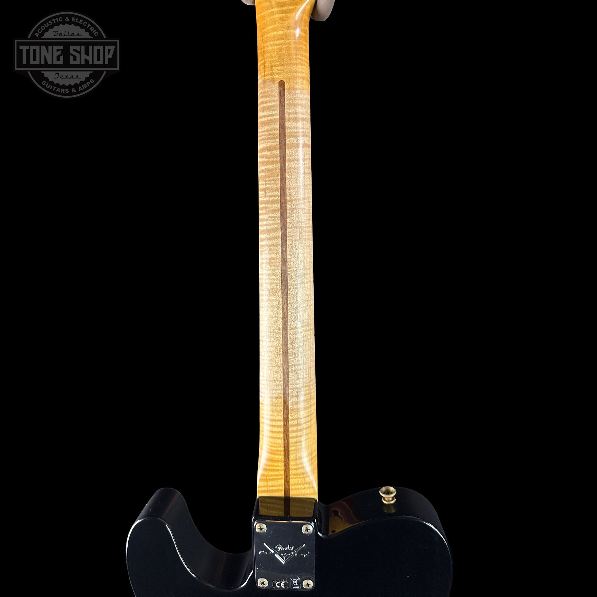 Guitar neck with a black body on a black background, featuring the Tone Shop logo.