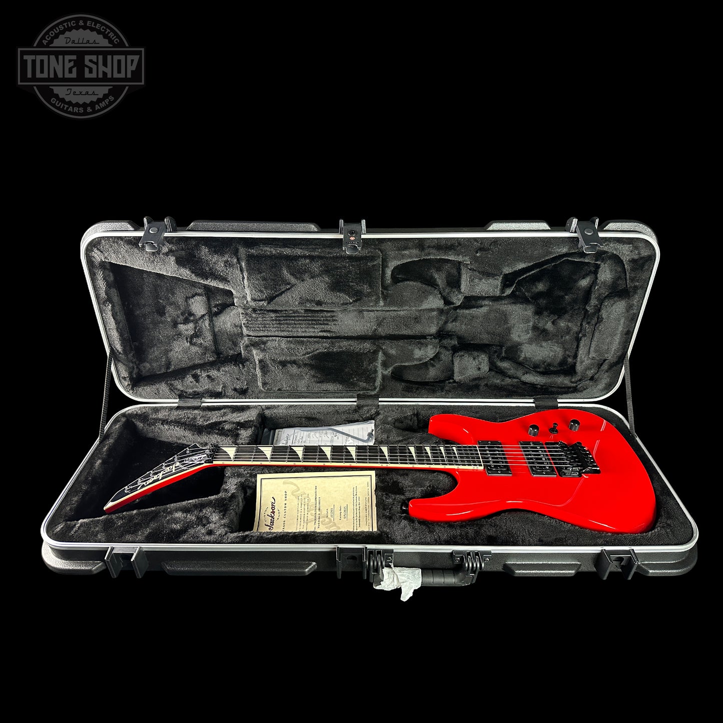 Red electric guitar in a hard case with 'Tone Shop' logo.