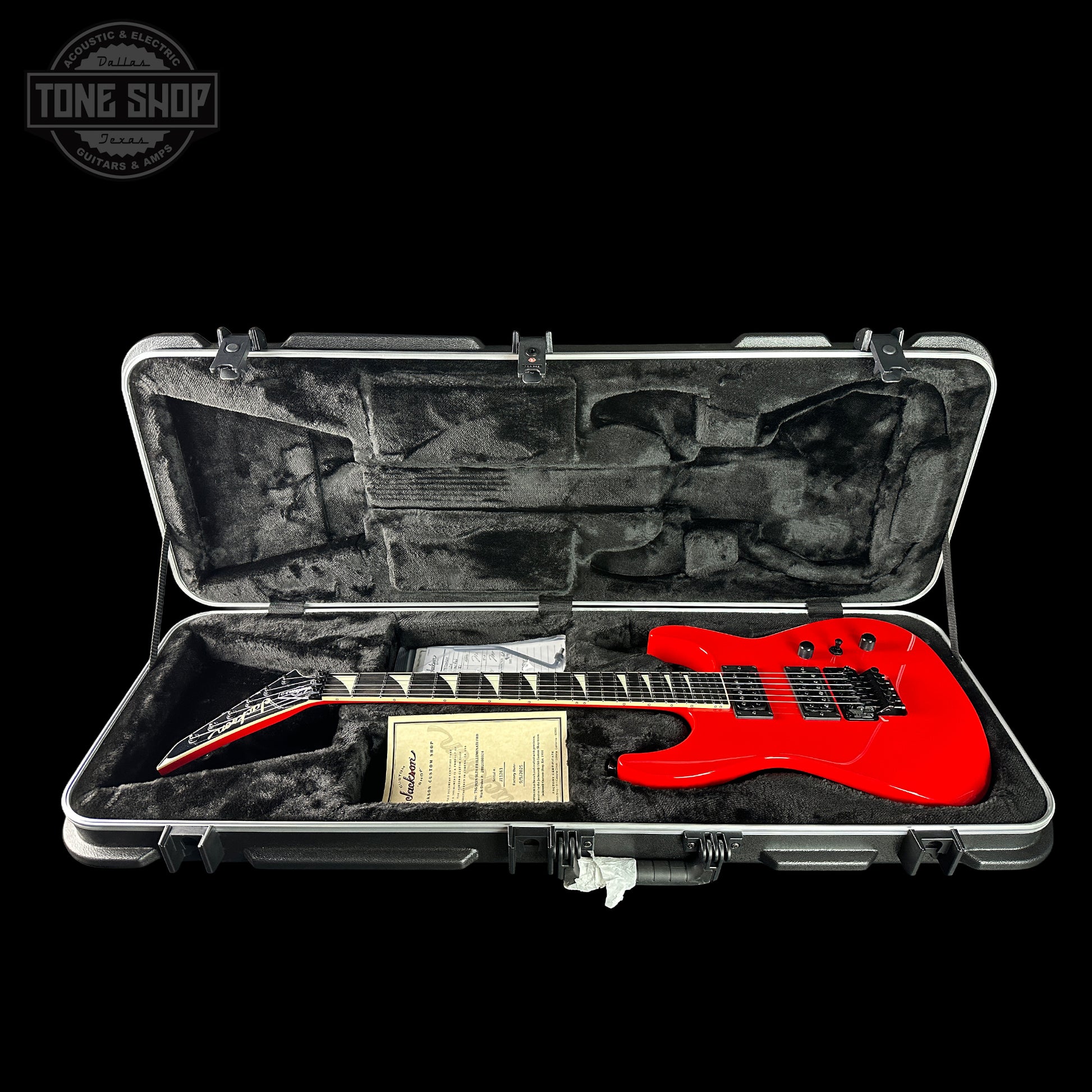 Red electric guitar in a hard case with 'Tone Shop' logo.