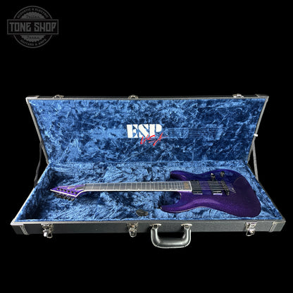 Purple electric guitar in an open blue case with ESP brand logo.