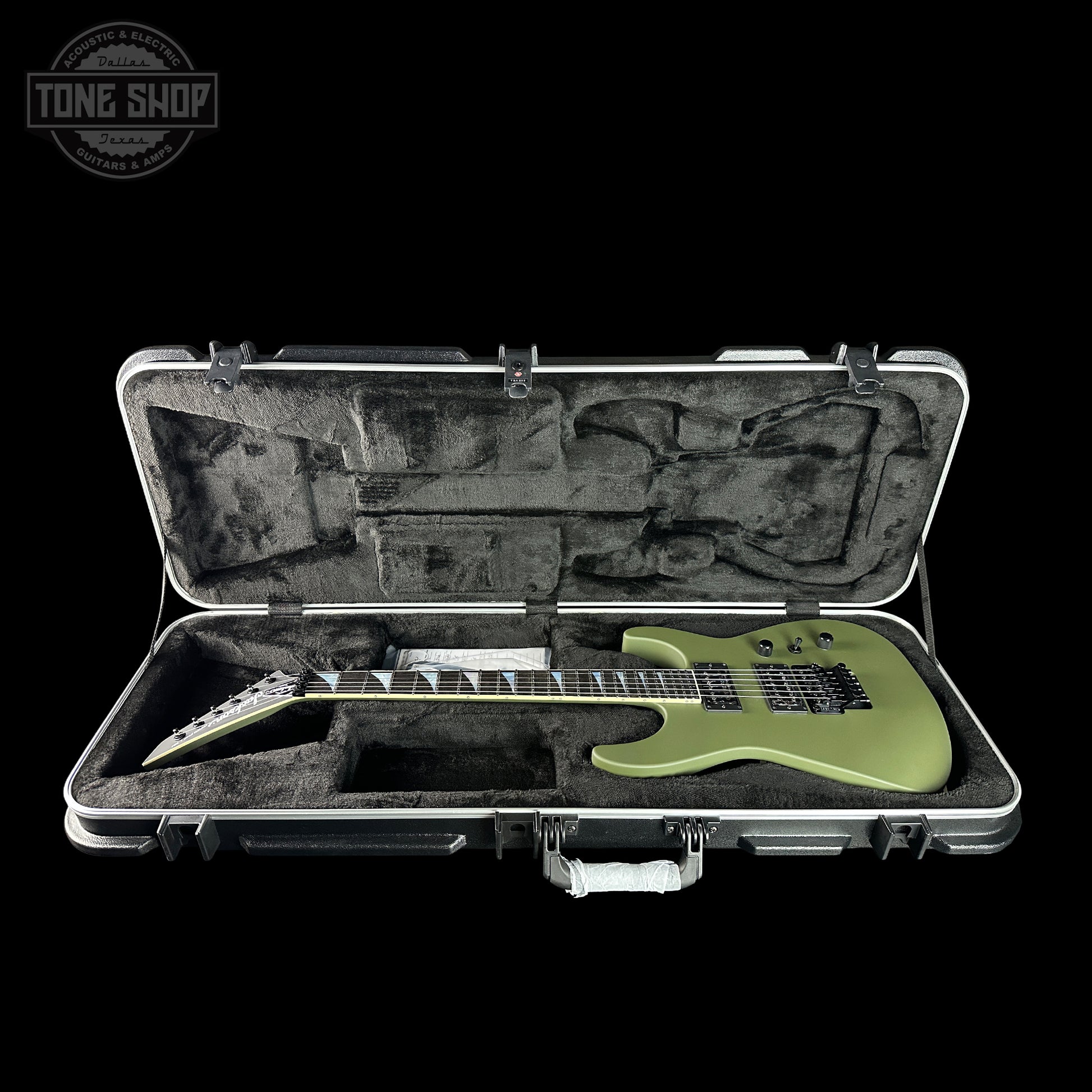 Green electric guitar in an open hard-shell case with 'Tone Shop' logo.