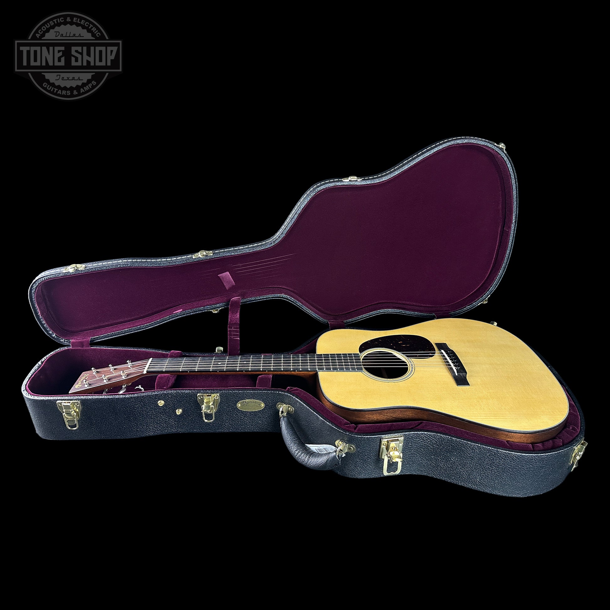 Acoustic guitar in a purple-lined hardshell case with 'Tone Shop' logo.