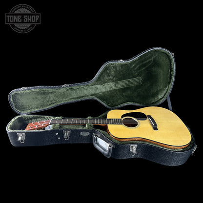 Acoustic guitar in a hard-shell case with 'Tone Shop' logo in the corner.