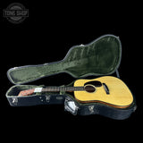 Acoustic guitar in a hard case with 'Tone Shop' logo in the corner.