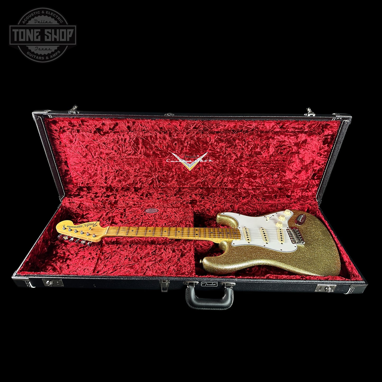 Gold electric guitar in a red-lined case with 'Tone Shop' logo.