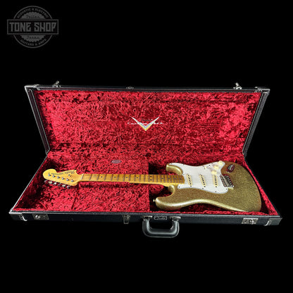 Gold electric guitar in a red-lined case with 'Tone Shop' logo.