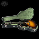 Acoustic guitar in a green hard case with 'Tone Shop' logo in the corner.