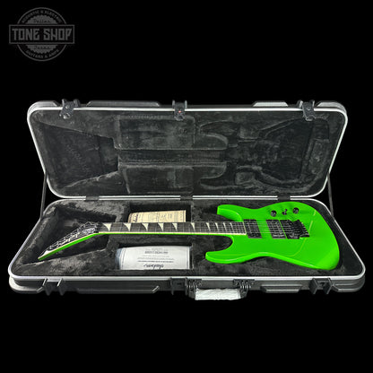 Green electric guitar in a case with 'Tone Shop' branding.