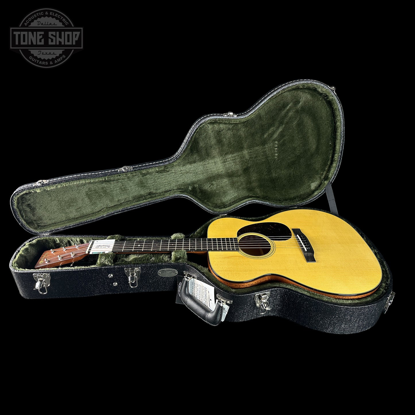 Acoustic guitar in a hard-shell case with 'Tone Shop' logo in the corner.