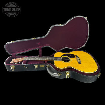 Acoustic guitar in a hard-shell case with 'Tone Shop' logo.