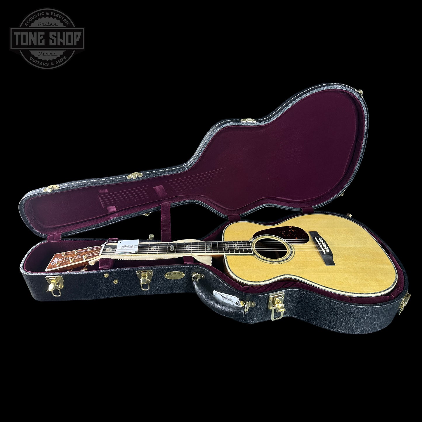 Acoustic guitar in a case with 'Tone Shop' logo in the corner